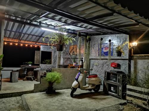 a motor scooter parked in a room with a table at Nong Or Blue House Resort in Sukhothai