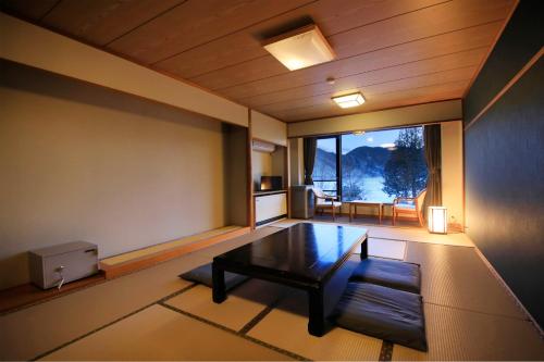 a living room with a table and a large window at Yutorelo Nikko in Nikko