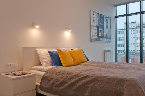 グディニャにあるCITYSTAY Abrahama Gdynia Apartmentのベッドルーム1室(黄色と青の枕付きのベッド1台付)