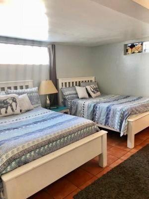 a bedroom with two beds and a window at Rosarito Beach House-- Spacious, Central, Beach View, & Sleeps 14 in Rosarito