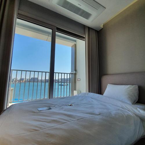 a bedroom with a bed and a large window at 쏘타스위트 속초 월드스테이트 in Sokcho