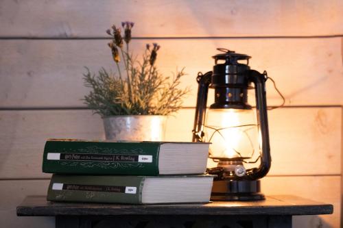 einem Tisch mit Büchern und einer Lampe auf einem Tisch in der Unterkunft Kanalmagasinets Pensionat in Söderköping
