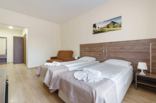 a hotel room with two beds and a chair at Meridian Hotel in Saint Petersburg