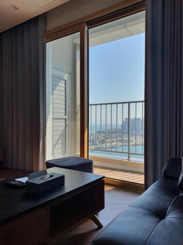a living room with a couch and a large window at World State Hotel Sokcho in Sokcho