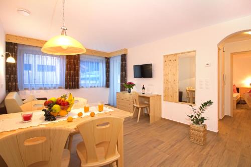 a dining room and living room with a table and chairs at Stiflerhof in Falzes
