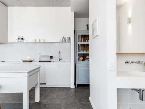 a white kitchen with white cabinets and a sink at Audrey in Byron Bay