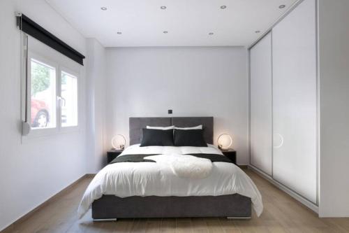 - une chambre avec un grand lit aux murs blancs dans l'établissement (B) Koukaki, A modern, newly refurbished Studio 4ppl, à Athènes