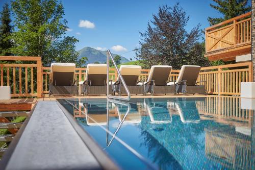 una piscina con un mucchio di sedie intorno di AlpenParks Hotel & Apartment Sonnleiten a Saalbach Hinterglemm