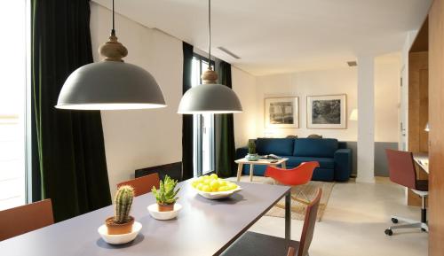 uma sala de estar com uma mesa e um sofá azul em Casa Neri Apartments em Barcelona
