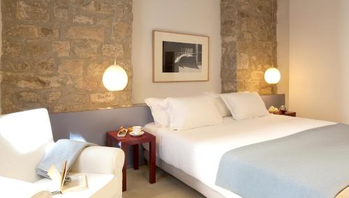 um quarto de hotel com duas camas e um sofá em Casa Neri Apartments em Barcelona