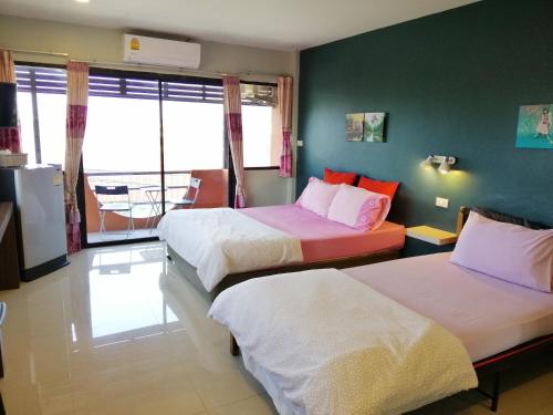 a hotel room with two beds and a balcony at ศรีกรุงดีลักซ์โฮเตล in Phra Nakhon Si Ayutthaya