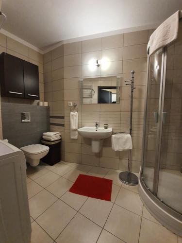 a bathroom with a sink and a toilet and a shower at Apartament w Porcie - 365PAM in Kołobrzeg