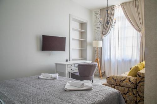 a bedroom with a bed and a desk and a television at Domestic House Lola in Vukovar