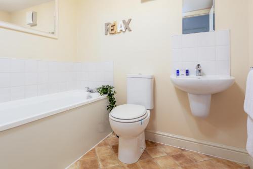 a white bathroom with a toilet and a sink at Granary Suite No22 - Donnini Apartments in Ayr