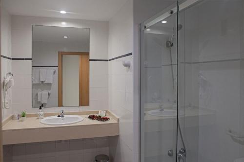 uma casa de banho com 2 lavatórios e uma cabina de duche em vidro. em VALHOTEL Residencia Tiempo Libre El Puig em El Puig