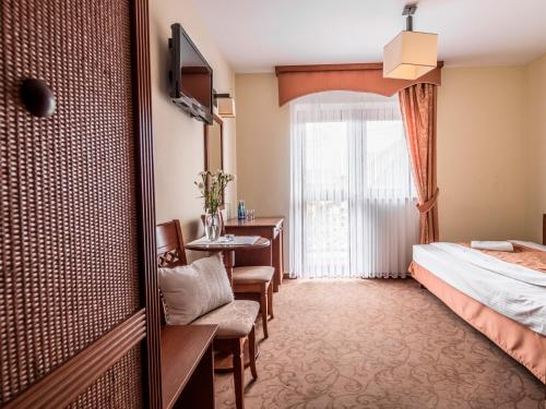 a hotel room with a bed and a window at Villa Magnat SPA, JACUZZI, SAUNA, TĘŻNIA SOLANKOWA in Białka Tatrzanska