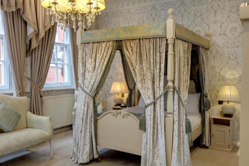 a bedroom with a canopy bed and a chandelier at St James Hotel; BW Premier Collection in Nottingham