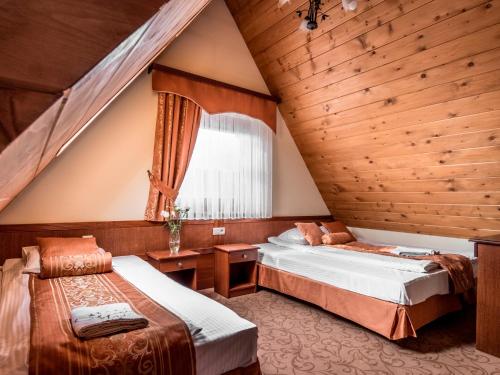 a bedroom with two beds and a window at Villa Magnat SPA, JACUZZI, SAUNA, TĘŻNIA SOLANKOWA in Białka Tatrzanska