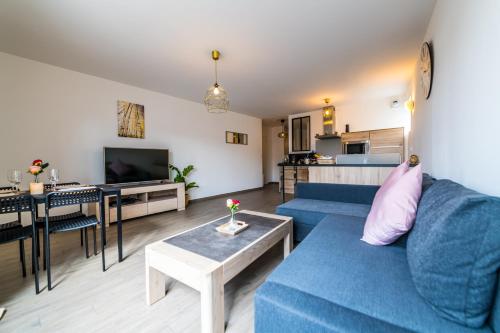 un salon avec un canapé bleu et une table dans l'établissement Le Gracieux situé en plein centre ville proche Disney Val dEurope Village Nature, à Lagny-sur-Marne