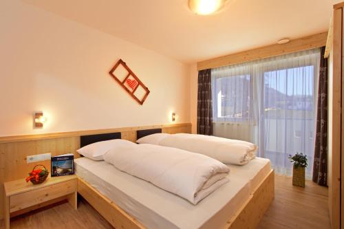 a bedroom with two beds and a window at Stiflerhof in Falzes