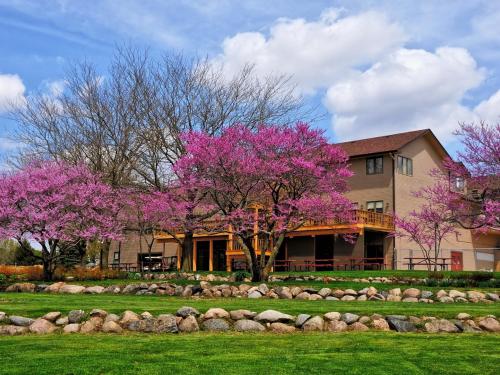 a house with pink flowering trees in front of it at Lake Panorama National Resort in Panora
