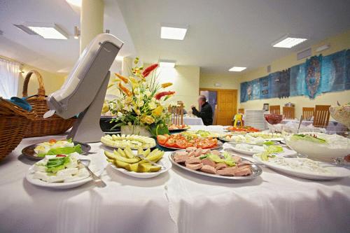 a white table with plates of food on it at Geovita Muszyna in Muszyna