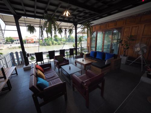 a living room with couches and chairs and a view of a river at Baan Keang Chon Ayutthaya บ้านเคียงชล อยุธยา in Phra Nakhon Si Ayutthaya