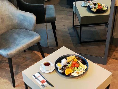 a bowl of food on a table next to a chair at FRT AİRLİNES OTEL in Arnavutköy