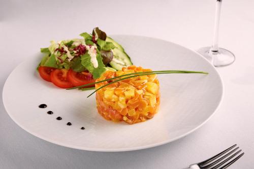 a white plate with a dish of food on a table at Hotel Charleroi Airport - Van Der Valk in Charleroi