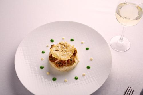 a white plate with food and a glass of wine at Hotel Charleroi Airport - Van Der Valk in Charleroi