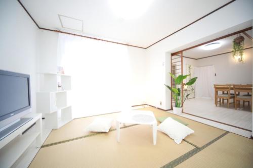 a living room with a tv and a table at Higashiomi Large House in Higashiomi