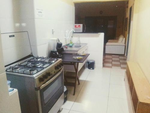 a kitchen with a stove and a table in it at Morada BemTeVi Guest House in São José dos Campos