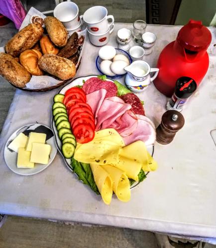a table with a plate of food with cheese and meats at Pokoje Mira in Torzym