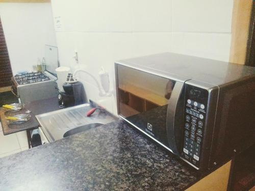 a microwave on a counter in a kitchen at Morada BemTeVi Guest House in São José dos Campos
