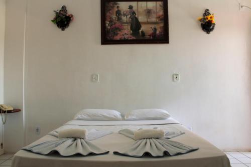 a bed with two pillows on it in a room at Hotel Rio Pregui&ccedil;as in Barreirinhas