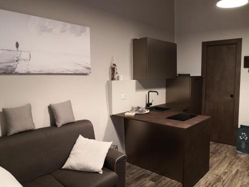 een woonkamer met een bank, een bureau en een stoel bij DOMUSCUNEO Barra di Ferro 2 tortora in Cuneo