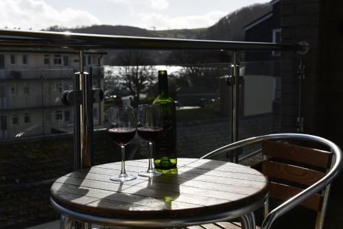 a table with two glasses and a bottle of wine at Dartside 1 in Dartmouth