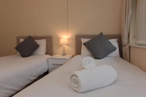 Duas camas com toalhas num quarto em Dartside 2 em Dartmouth