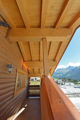 a porch of a log cabin with a wooden roof at Hotel L'espoir in Champoluc