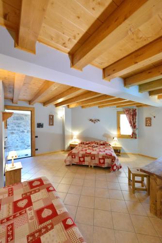 a bedroom with a bed in a room with wooden ceilings at Hotel L'espoir in Champoluc