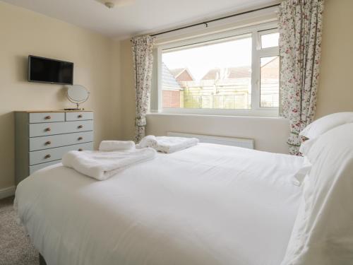 a bedroom with a large white bed and a window at Arbour Retreat in Filey