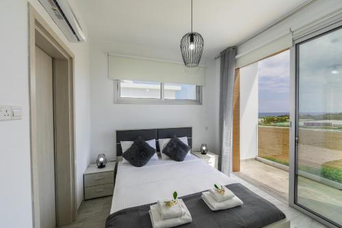 Un dormitorio con una cama y una ventana grande. en Protaras Villa Alasia, en Protaras