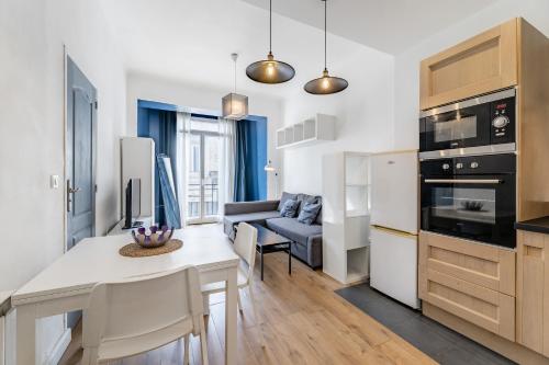 une cuisine et un salon avec une table et un canapé dans l'établissement CHARMING BRIGHT AND EQUIPPED APARTMENT, à Marseille