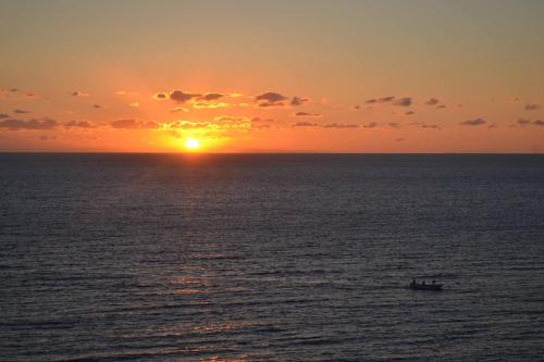 a sunset over the ocean with a boat in the water at Villa Cigaline in Tiggiano