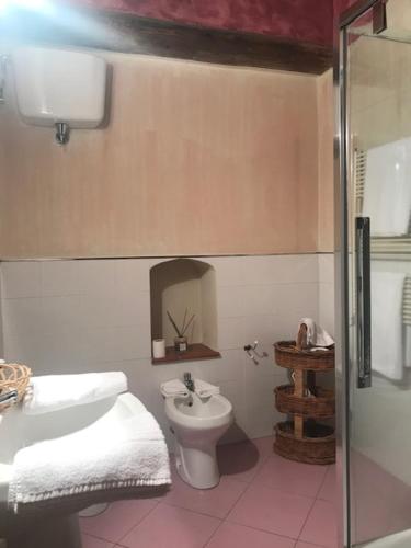 a bathroom with a toilet and a sink and a shower at La Locanda del Loggiato in Bagno Vignoni