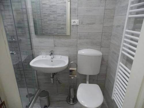 a bathroom with a sink, toilet and mirror at Appartamenti del Dose in Venice