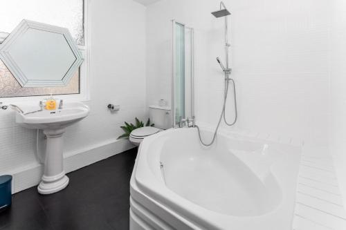 a white bathroom with a white tub and a sink at Air Host and Stay - Stanley House Large house, sleeps 10 5 mins to city centre in Liverpool
