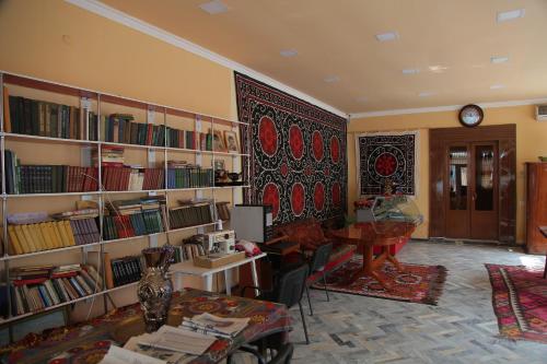 uma sala com uma biblioteca com estantes e uma mesa em Hostel Gulsara em Samarcanda