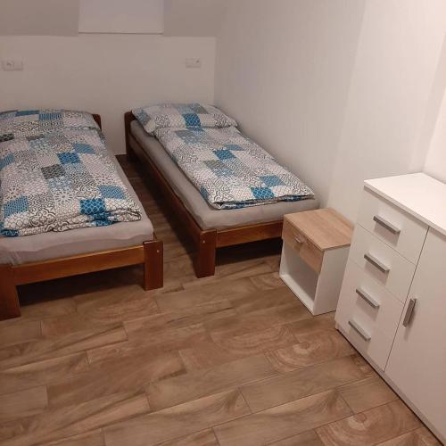 two beds in a room with wooden floors at U Matěje in Mutěnice