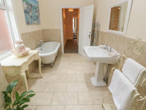 ein Badezimmer mit zwei Waschbecken, einer Badewanne und einem Waschbecken in der Unterkunft Hazelmere Cottage in Worksop